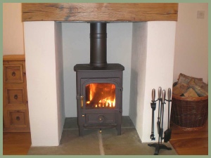 Woodburning stove in the sitting room at Meadow Barn - logs provided